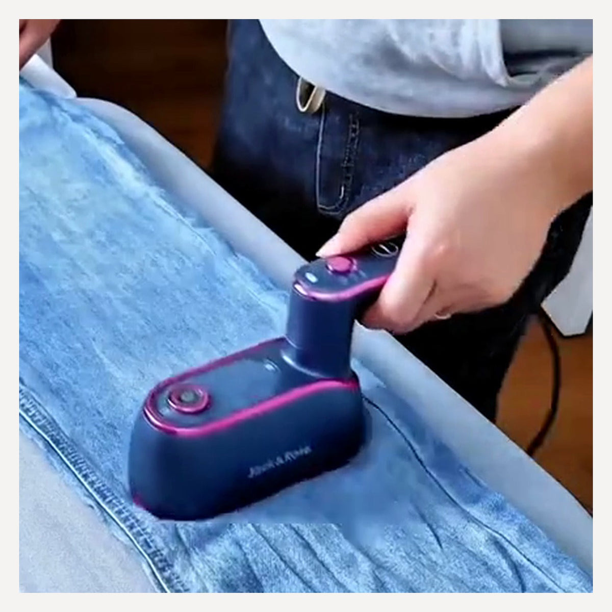 Portable steam iron being used on denim fabric